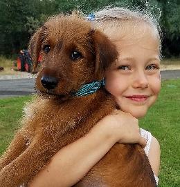 little girl holding her puppy